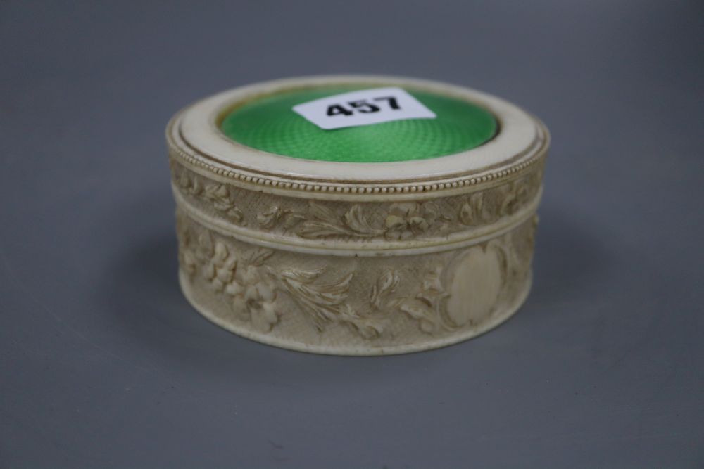 A carved ivory box with an enamel inlaid top, diameter 9.5cm height 4.5cm